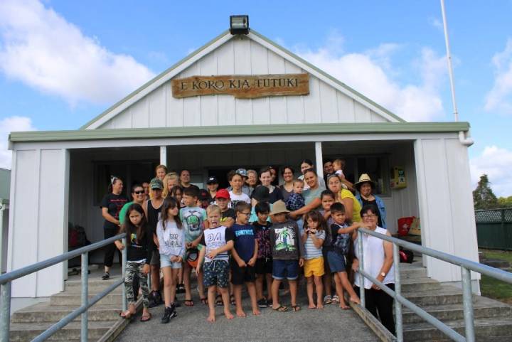 Community standing in front of wharenui